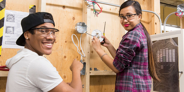 picture of two centennial college electrical engineering students working in a lab with safety equipment